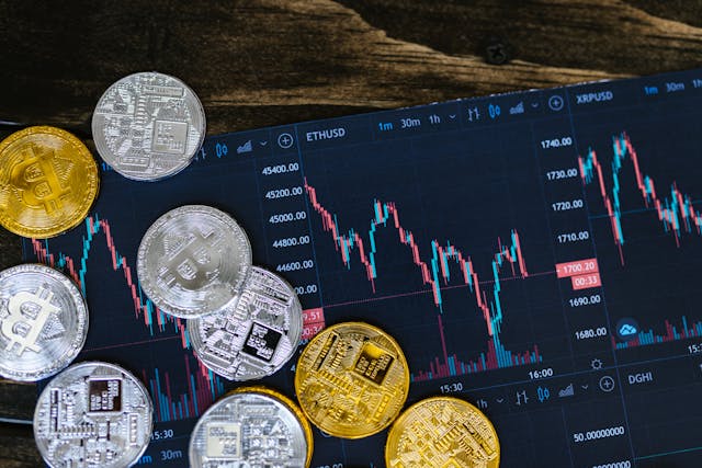 Physical-cryptocurrency-coins-on-a-tablet-displaying-ETH-and-XRP-price-charts